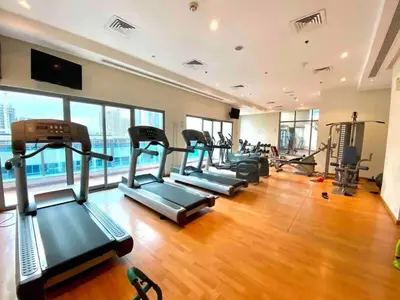 a gym with a row of treadmills and elliptical machines at lovely Studio in Dubai Marina near beach Z1009 in Dubai