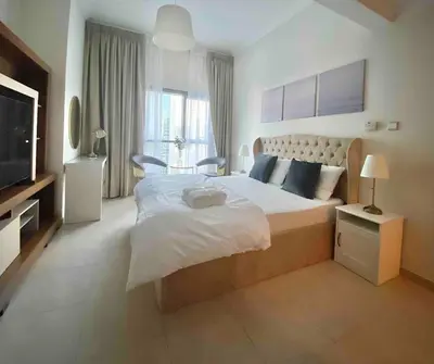 a bedroom with a large bed and a television at lovely Studio in Dubai Marina near beach Z1009 in Dubai