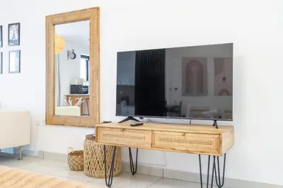 a living room with a tv and a mirror at SuCasa in Dubai