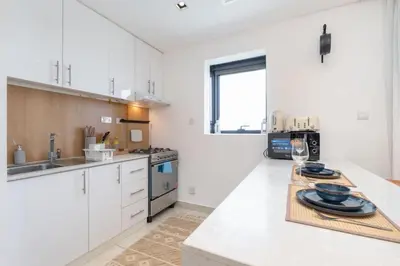 a kitchen with white cabinets and a counter top at SuCasa in Dubai
