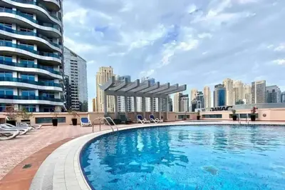 a swimming pool on the roof of a building with a city at Studio in Dubai Marina near beach and Metro Z514 in Dubai