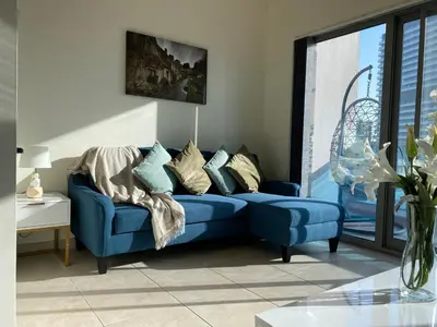 a blue couch in a living room with a window at 1Bedroom Apartment in Dubai Marina near to beach & Metro Z1006 in Dubai
