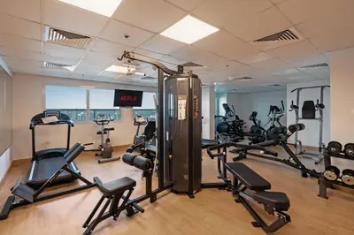 a gym with several treadmills and exercise bikes at Stunning studio at sports city in Dubai