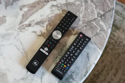 two remote controls sitting on top of a counter at Stunning studio at sports city in Dubai