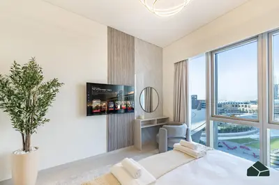 a bedroom with a bed and a large window at Grande Signature Deluxe Next to Dubai Opera by BMS in Dubai