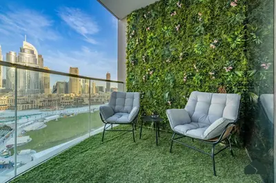 two chairs on a balcony with a green wall at Grande Signature Deluxe Next to Dubai Opera by BMS in Dubai