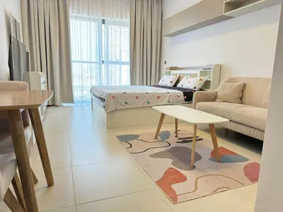 a room with a bed and a couch and a table at Spacious Studio with Burj Khalifa Views in Dubai
