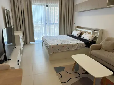 a room with a bed and a couch and a tv at Spacious Studio with Burj Khalifa Views in Dubai