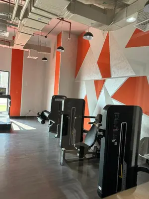 an empty gym with chairs and a wall with orange at Spacious Studio with Burj Khalifa Views in Dubai