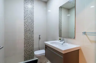 a bathroom with a sink and a toilet and a mirror at ShoresInn - Dubai Marina's Classic Stay in Dubai
