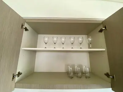 a cupboard with four empty wine glasses on shelves at Grande signature residence Smart Burj khalifa Fountains view large 3 bedroom hall 4 bathroom view burj khalifa Fountains from hall and rooms balcony in Dubai