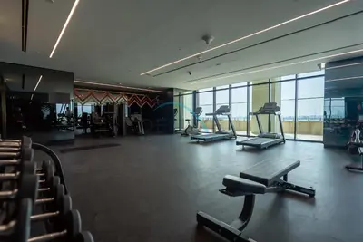 a gym with several treadmills and chairs in a building at Exclusive Promo Modern 1BR with Partial Canal Views by Deluxe Holiday Homes in Dubai