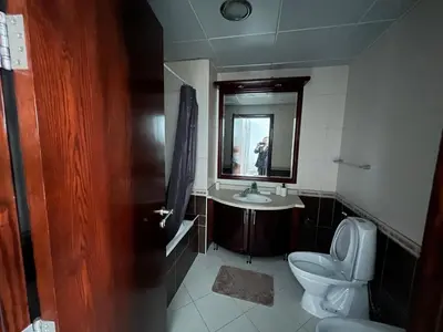 a bathroom with a toilet and a sink and a mirror at Opal Tower in Dubai