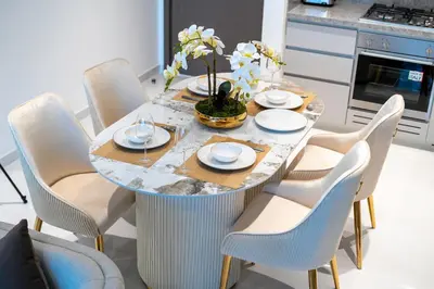 a dining room table with chairs and a table with plates at Exclusive Beachfront 2 Bed with Pool & Palm View in Dubai