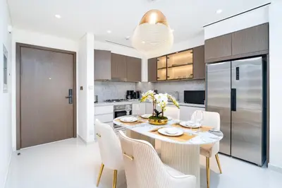 a kitchen with a dining room table and chairs at Exclusive Beachfront 2 Bed with Pool & Palm View in Dubai