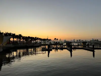 a sunset over a body of water with palm trees at Stunning 1BR Apartment High floor Creek Harbour in Dubai