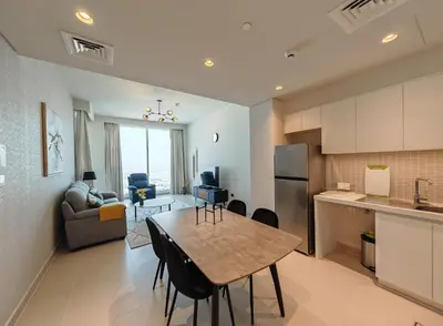 a kitchen and a living room with a table in a room at Stunning 1BR Apartment High floor Creek Harbour in Dubai
