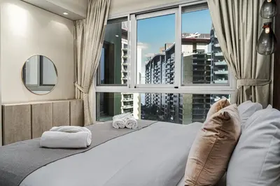 a bedroom with a large bed with a large window at Marina Haven I Waterfront I Pool I Gym and Sauna in Dubai