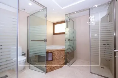 a bathroom with a glass shower and a toilet at Luxurious Meydan Dubai 6 BED Villa Unparalleled Views in Dubai
