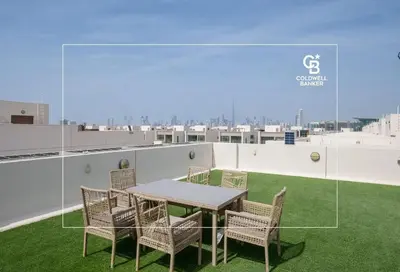 a table and chairs on the roof of a building at Luxurious Meydan Dubai 6 BED Villa Unparalleled Views in Dubai