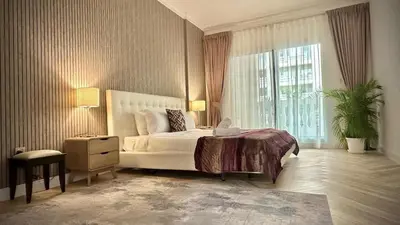 a bedroom with a large bed and a large window at Modern 1BR Retreat with Balcony in Vibrant JVC by Bhavan Vacation Homes in Dubai