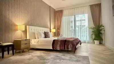 a bedroom with a white bed and a large window at Modern 1BR Retreat with Balcony in Vibrant JVC by Bhavan Vacation Homes in Dubai