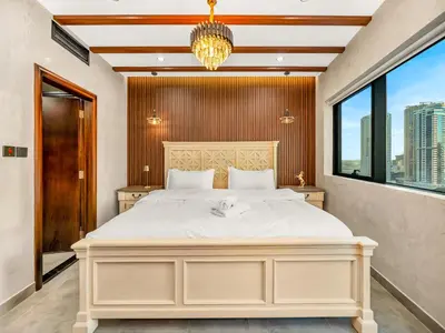 a bedroom with a large white bed and a window at Luxury 2BR Apartment with Full Marina Views in Dubai