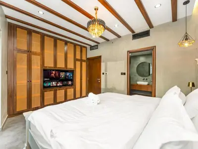a bedroom with a large white bed and a tv at Luxury 2BR Apartment with Full Marina Views in Dubai