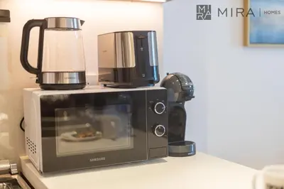 a microwave with a coffee maker on top of it at Mira Holiday Homes - Newly 2 bedroom in La Sirene, Port De La Mer in Dubai