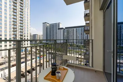 a balcony with a table and a view of a city at Comfortable Stylish Haven - Great Community in Dubai