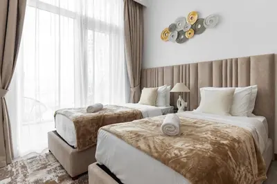 a hotel room with two beds and a window at SIMPLY COMFORT in Missoni Top Floor with Sea, Canal and Burj Khalifa Views in Dubai