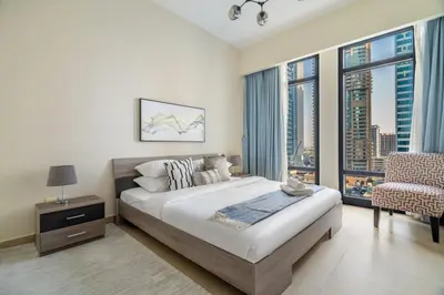 a bedroom with a bed and a large window at GuestReady - Magnificent stay with lake view in Dubai