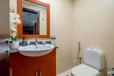 a bathroom with a sink and a toilet and a mirror at GuestReady - Magnificent stay with lake view in Dubai