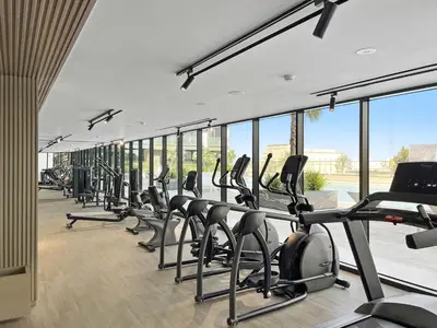 a gym with a row of cardio bikes and treadmills at Stunning 1 br modern luxury residence at JVC in Dubai