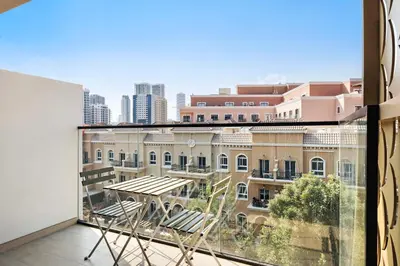 a balcony with chairs and a view of a building at Stunning 1 br modern luxury residence at JVC in Dubai