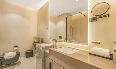 a bathroom with a sink and a toilet and a mirror at 2BR Jumeirah Gate 1, Marina Skyline View in Dubai