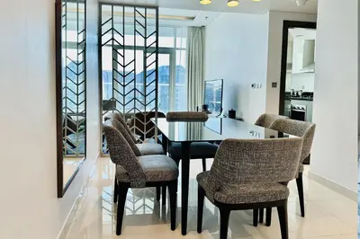 a dining room with a black table and chairs at Vserve Stylish Suite 1 BR with Burj Khalifa and Canal view in Dubai