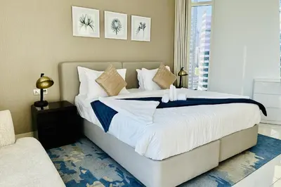 a bedroom with a large bed and a window at Vserve Stylish Suite 1 BR with Burj Khalifa and Canal view in Dubai