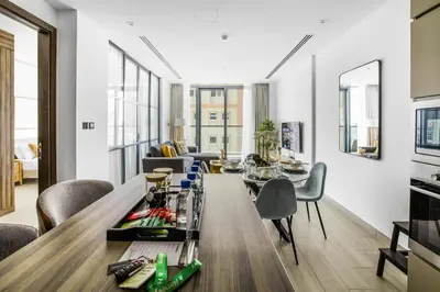 a living room with a long table and chairs at Comfy 1BR w Cinema Room Business Centre Pool Table and Sauna in Dubai