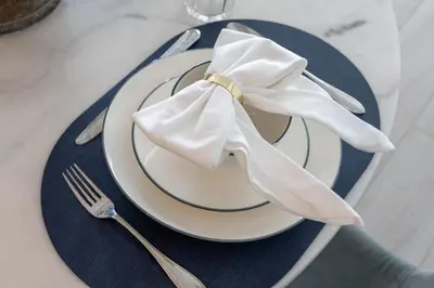 a plate with a napkin on a table with a fork and knife at Comfy 1BR w Cinema Room Business Centre Pool Table and Sauna in Dubai