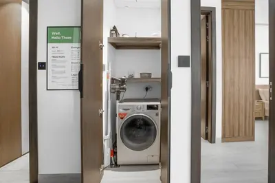 a door to a washing machine in a room at Comfy 1BR w Cinema Room Business Centre Pool Table and Sauna in Dubai