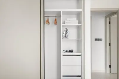 a closet with white shelves and a mirror at Silkhaus Seaside 2BDR in Marina Vista Beachfront in Dubai