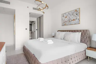 a white bedroom with a large bed with white pillows at Silkhaus Seaside 2BDR in Marina Vista Beachfront in Dubai