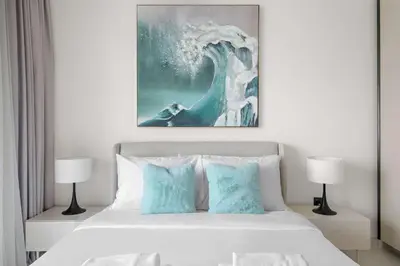 a bedroom with a bed with a painting on the wall at Silkhaus Seaside 2BDR in Marina Vista Beachfront in Dubai
