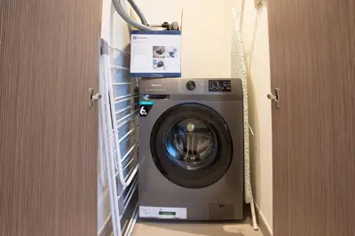 a washing machine in a laundry room with a door at Prime Downtown Location 2BR Apt Burj Royale in Dubai