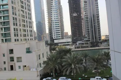 a view of a city with tall buildings and palm trees at One bed apartment at a great location in Dubai Marina in Dubai