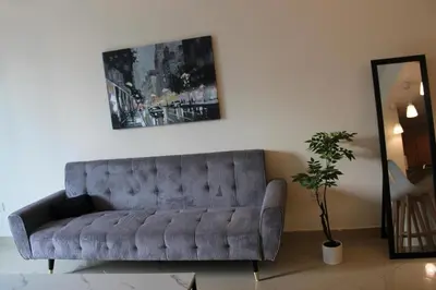 a living room with a couch and a potted plant at One bed apartment at a great location in Dubai Marina in Dubai