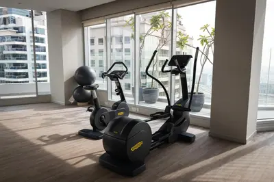 a gym with cardio machines in a room with windows at Stunning 1BR in heart of Dubai Marina in Dubai