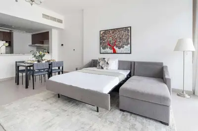 a bedroom with a bed and a chair and a table at Frank Porter - Park Gate in Dubai