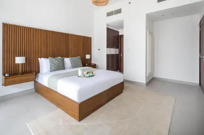 a bedroom with a large bed with a wooden headboard at Frank Porter - Park Gate in Dubai